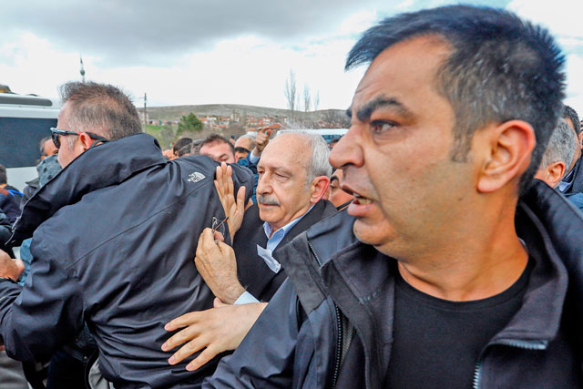 Chairman of the Republican People's Party Kemal Kilicdaroglu (centre) is protected by bodyguards after he was attacked by protesters on Sunday while attending a funeral ceremony in Ankara's Cubuk district for a soldier killed in fighting against Kurdish militants (AFP photo)