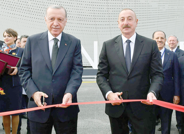This handout photograph taken and released on Thursday by the Press service of the President of Azerbaijan, shows Turkish President Recep Tayyip Erdogan (left) and Azerbaijani President Ilham Aliyev  cutting the ribbon during the inauguration ceremony of Zangilan airport (AFP photo)