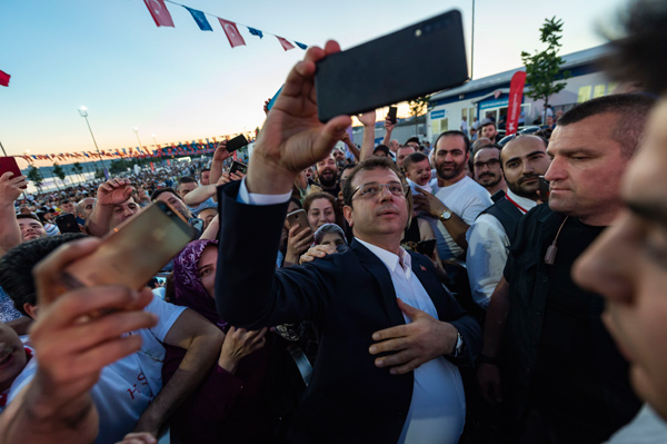 Ekrem Imamoglu (centre), Istanbul mayoral candidate of the main opposition Republican People’s Party (CHP), take selfies with supporters during an election campain at Zeytinburnu district in Istanbul on May 29 (AFP photo)