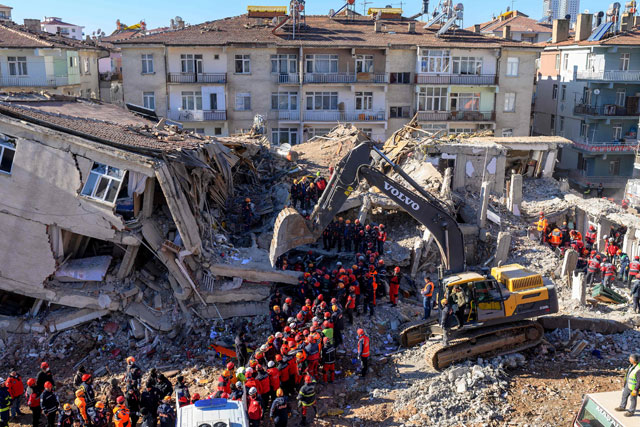 Rescue workers remove corpses from the rubble of a building after an earthquake in Elazig, eastern Turkey, on Sunday (AFP photo)