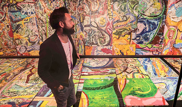 Dubai-based British contemporary British artist Sacha Jafri stares at fragments of his painting entitled 'The Journey of Humanity', in the Emirati city of Dubai, on Thursday (AFP photo)