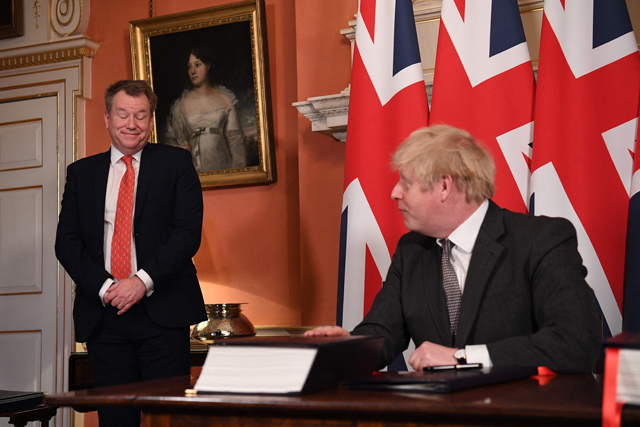 In this file photo taken on December 30, 2020, UK chief trade negotiator David Frost (left) looks on as Britain's Prime Minister Boris Johnson signs the Trade and Cooperation Agreement between the UK and the EU, the Brexit trade deal, at 10 Downing Street in central London (AFP photo)