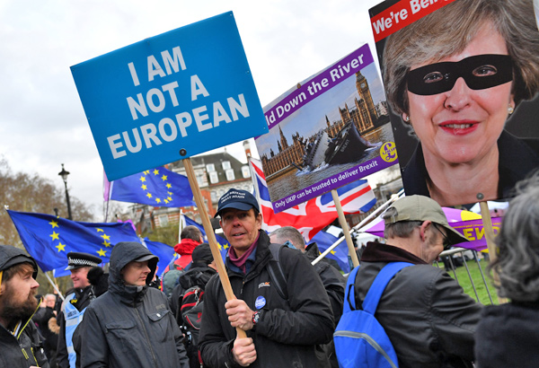 A pro-Brexit protester holds up a sign outside the Houses of Parliament in London, Britain, on Thursday  (Reuters photo)