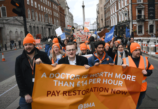 Demonstrators hold placards during a march by so-called ‘junior doctors’, physicians who are not senior specialists but who may have years of experience, through central London on Tuesday (AFP photo)