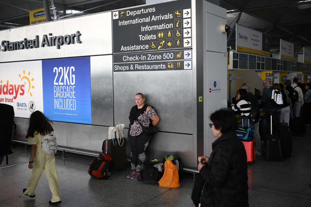 Passengers wait at Stansted Airport, north of London, on Tuesday after UK flights were delayed over a technical issue (AFP photo)