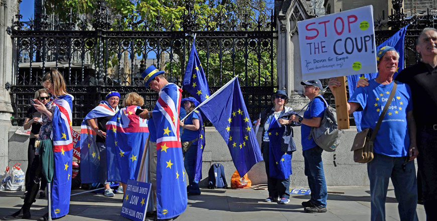 Anti-Brexit activists wave EU flags whilst draped in Union flags as they demonstrate outside the Houses of Parliament in London on Thursday (AFP photo)