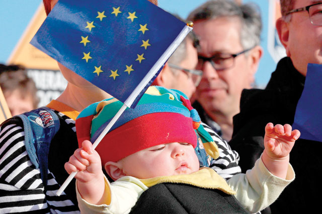 A Liberal Democrat supporter's baby holds an EU flag as they wait for the arrival of Britain's Liberal Democrat leader Jo Swinson at a general election campaign event at Esher Rugby Club in Esher, south west London, on Wednesday (AFP photo)