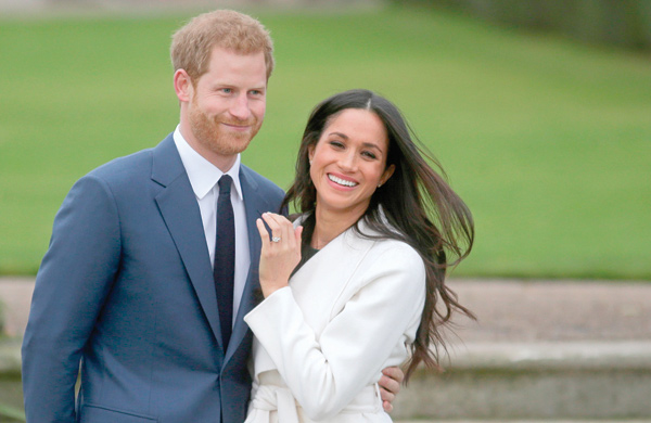  Britain’s Prince Harry stands with his fiancee US actress Meghan Markle as she shows off her engagement ring whilst they pose for a photo in the Sunken Garden at Kensington Palace in west London, following the announcement of their engagement, on November 27, 2017 (AFP photo)