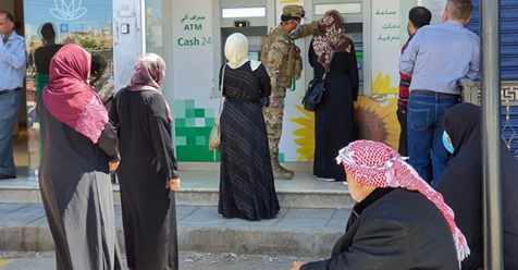 Refugees in Amman wait in line to withdraw their cash assistance from the UNHCR, which will be distributed to a total of 18,000 families (Photo courtesy of UNHCR Jordan)