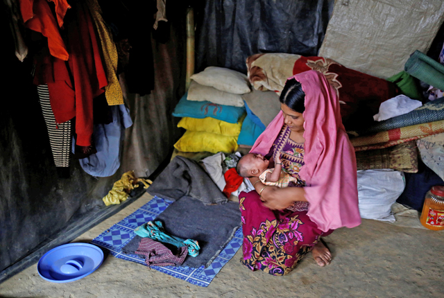Minara Begum, 22, holds her one-month-old son Ayub as she sits inside their shelter in Kutupalang unregistered refugee camp in Cox Bazar, Bangladesh, February 10 (Reuters photo)