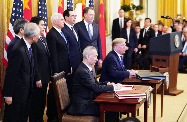 US President Donald Trump (right) and China's Vice Premier Liu He, the country's top trade negotiator, sign a trade agreement between the US and China during a ceremony in the East Room of the White House in Washington, DC, on Wednesday (AFP photo)