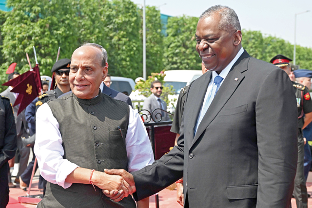 India's Defence Minister Rajnath Singh shakes hands with US Secretary of Defence Lloyd Austin before his ceremonial reception at the Manekshaw Centre in New Delhi on Monday  (AFP photo)