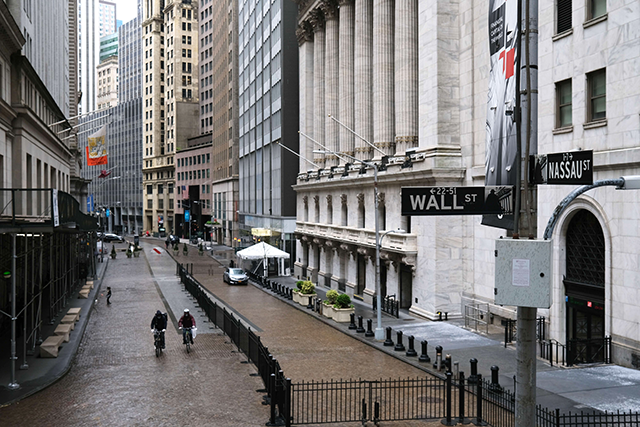 People walk across from the Stock Exchange as the coronavirus keeps financial markets and businesses mostly closed on May 08, in New York City (AFP photo)