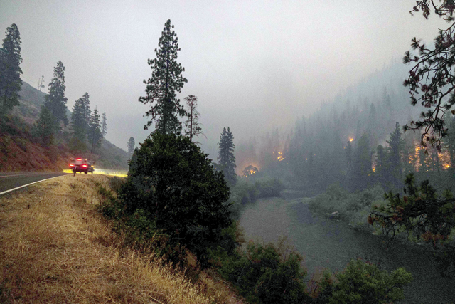 Flames burn to the Klamath River during the McKinney Fire in the Klamath National Forest northwest of Yreka, California, on Sunday (AFP photo)