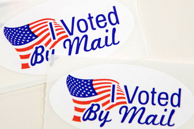 Stickers that read 'I Voted By Mail' sit on a table waiting to be stuffed into envelopes by absentee ballot election workers at the Mecklenburg County Board of Elections office in Charlotte, NC, on Friday (AFP photo)
