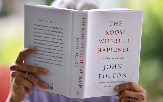 This file illustration photo taken on June 23 in Glendale, California, shows a woman reading John Bolton’s book ‘The Room Where it Happened’ on the day of its release in Los Angeles  (AFP photo)