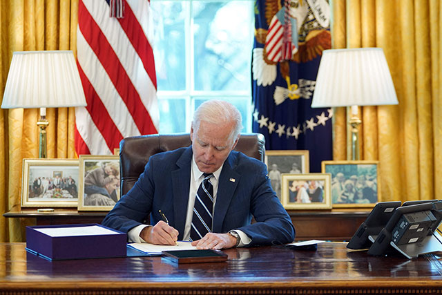 US President Joe Biden signs the American Rescue Plan on Thursday, in the Oval Office of the White House in Washington, DC (AFP photo)
