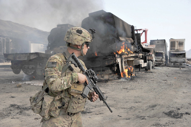 In this file photo a US soldier investigates the scene of a suicide attack at the Afghan-Pakistan border crossing in Torkham, Nangarhar province, on June 19, 2014 (AFP photo)