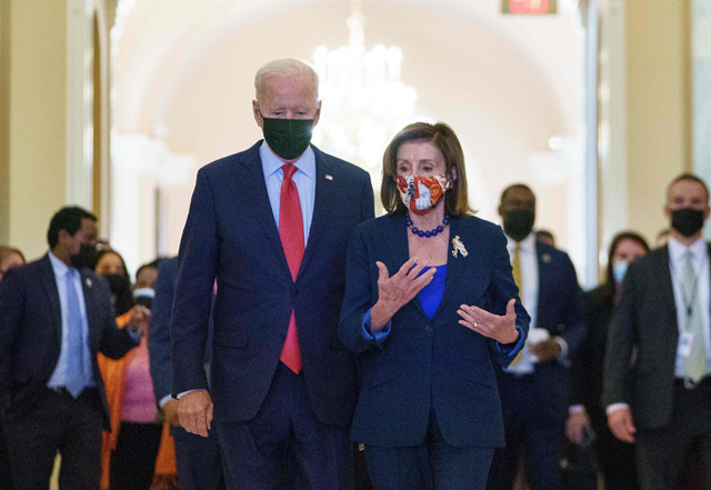 US President Joe Biden walks with Speaker of the House Nancy Pelosi as he departs the US Capitol after a caucus meeting in Washington, DC, on Friday (AFP photo)