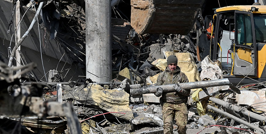 A Ukrainian serviceman carries a fragment of a rocket outside a building in Kyiv on Thursday, after it was destroyed by Russian shelling (AFP photo)
