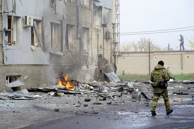 A serviceman guards the site of a car bomb explosion outside a building housing a local TV station in Melitopol on Tuesday (AFP photo)