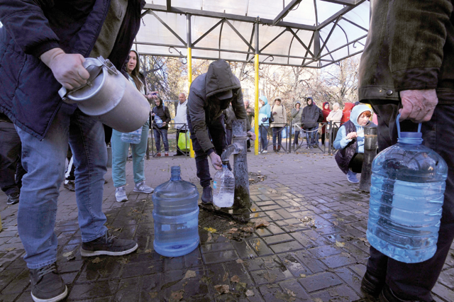 Local residents wait in line to collect water from a public water pump in a park of Kyiv on Monday (AFP photo)