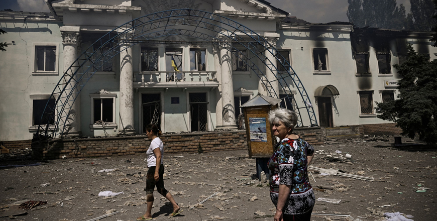 Two women looks at the destroyed Community Art Centre after a strike reportedly killed four people in the city of Lysychansk in the eastern Ukrainian region of Donbas on Friday (AFP photo)