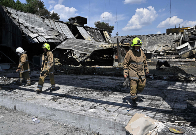 Rescuers walk in the destroyed Amstor mall in Kremenchuk, on Wednesday, two days after it was hit by a Russian missile strike, according to Ukrainian authorities (AFP photo)