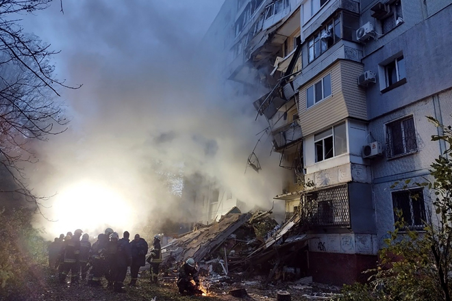 Rescuers gather past a residential building damaged after a strike in Zaporizhzhia, amid the Russian invasion of Ukraine, on Sunday  (AFP photo)