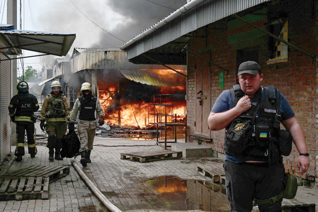 Firefighters work to control flames at the central market of Sloviansk on Tuesday, following a suspected missile attack amid the Russian invasion of Ukraine (AFP photo)