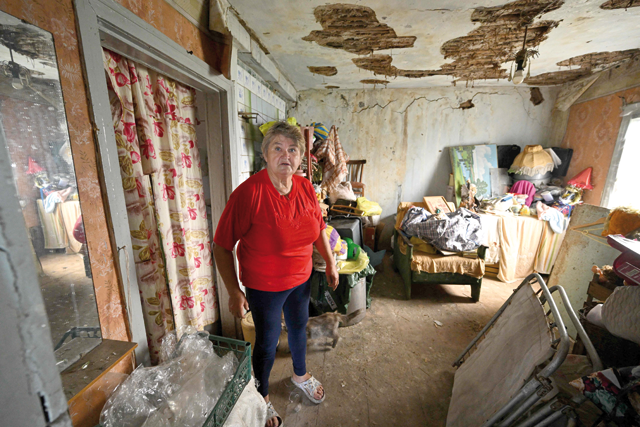 Local resident Nadiya, 67, shows a heavily damaged house in the village of Staryi Karavan, Donetsk region, on Friday, amid the Russian invasion of Ukraine (AFP photo)