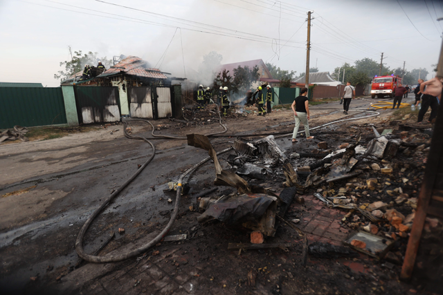Firefighters work on a site following a missile attack in a village outside Kyiv on Wednesday, amid the Russian invasion of Ukraine (AFP photo)
