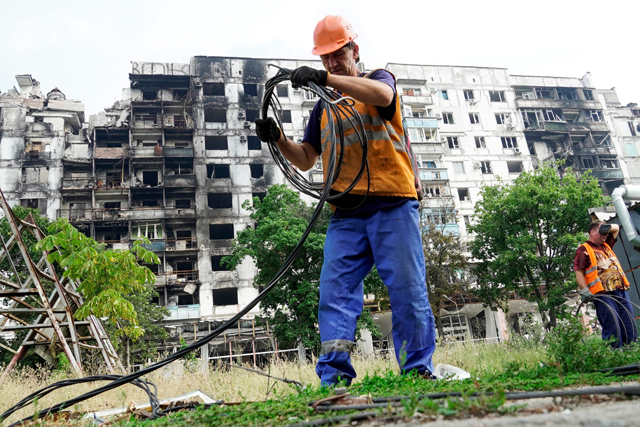 Workers restore electrical networks in the city of Mariupol on Monday, amid the ongoing Russian military action in Ukraine (AFP photo)