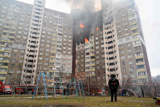 A law enforcement officer stands next to a residential building, damaged as a result of a missile attack in Kyiv on Wednesday (AFP photo)