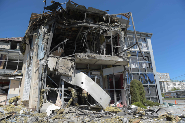 Military investigators work on the site of the damaged building housing the Paradise restaurant following a strike in Donetsk, Russian-controlled Ukraine, on Saturday (AFP photo)