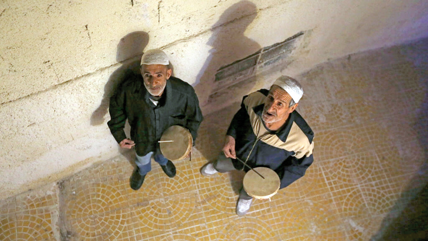 Traditional dawn awakeners known as ‘Musaharati’ beat drums and chant religious songs to wake up Muslims before sunrise for the ‘suhur’ meal before the day’s fast during the holy month of Ramadan  (AFP photo)