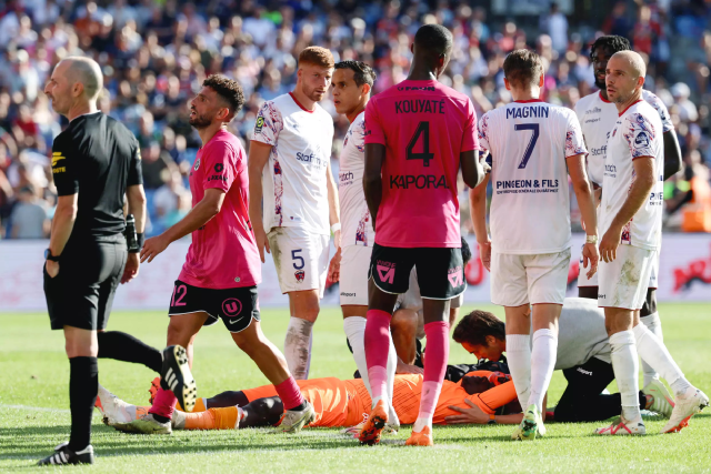 Clermont goalkeeper Mory Diaw (centre) lies on the ground after a firecracker exploded next to him during his side’s Ligue 1 game at Montpellier (AFP photo)