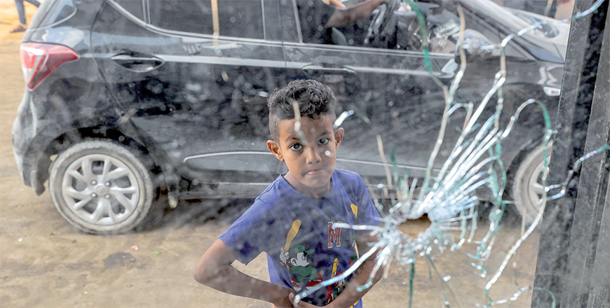 A boy looks at a bullet hole through a glass window after a raid by Israeli occupation forces in the Jenin camp for Palestinian refugees on Wednesday (AFP photo)