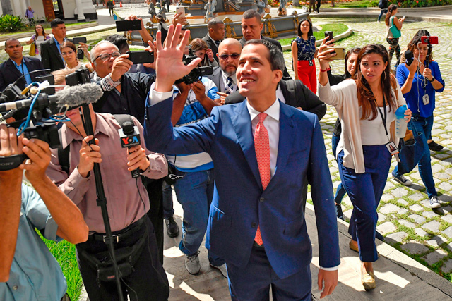 Venezuelan opposition leader and self-proclaimed acting president Juan Guaido waves as he arrives for a session at the national assembly in Caracas, on Tuesday (AFP photo)