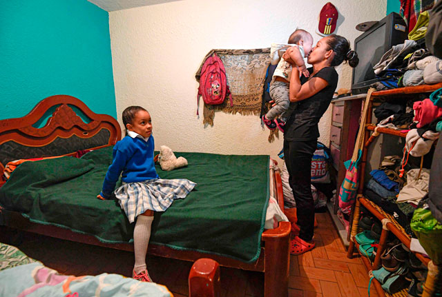 Venezuelan Yisela Palencia holds her baby Wilbelys next to her oldest daughter during an interview in Bogota, on July 4 (AFP photo)