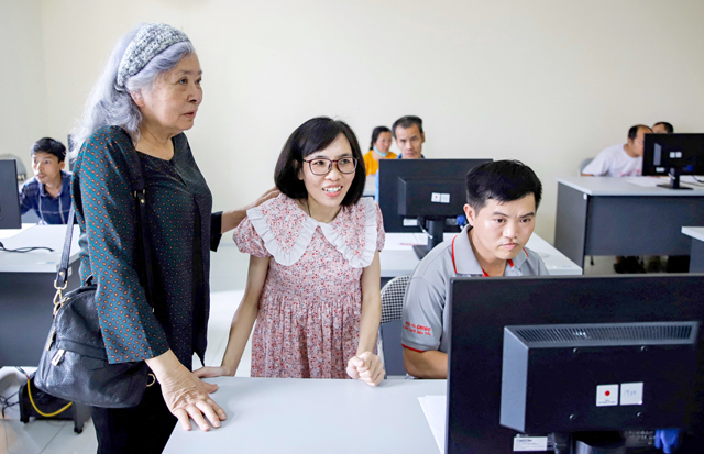 This photo taken on May 16shows Tran To Nga (left) visiting a computer class at Hanoi's centre for victims of Agent Orange dioxin (AFP photo)