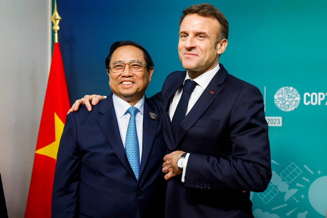 France's President Emmanuel Macron greets Vietnam's Prime Minister Pham Minh Chinh during a bilateral meeting on the sideline of the COP28 United Nations climate summit in Dubai on Saturday (AFP photo)