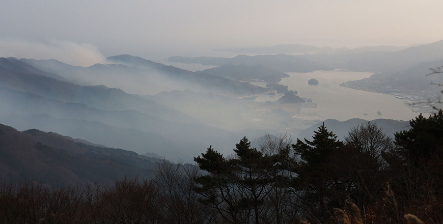 Smoke rises from a wildfire as officials continue to fight the blaze by Ofunato Bay, near the city of Ofunato, Iwate Prefecture on Friday (AFP photo)