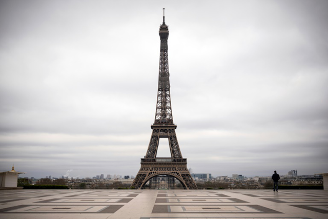 A man walks on the deserted square in front of the Eiffel Tower on Saturday -- worldwide, almost one billion people have been asked to stay at home to curb the spread of the novel coronavirus (AFP photo)