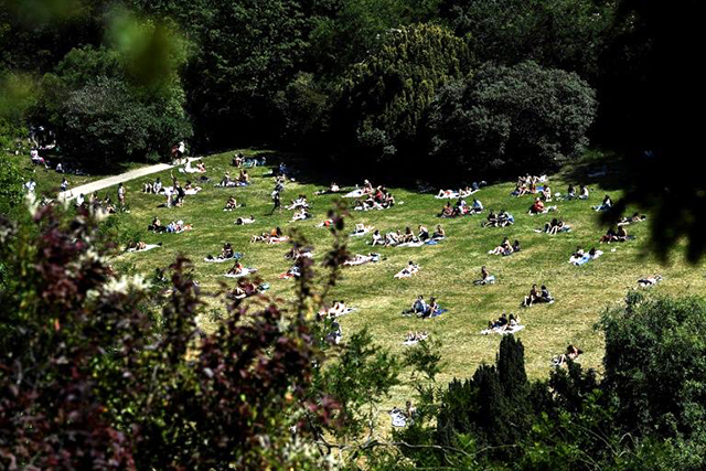 People enjoy the sun in Paris's Parc des Buttes Chaumont, as the French capital reopens it parks and gardens (AFP photo)