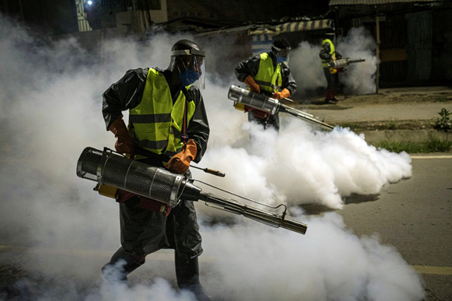 Volunteers fumigate a street in Nairobi to curb the spread of COVID-19 (AFP photo)