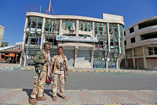 Houthi fighters pose for a photo in front of a damaged building on a street where Houthis have recently clashed with forces loyal to slain Yemeni former president Ali Abdullah Saleh in Sanaa, Yemen, on Wednesday (Reuters photo)