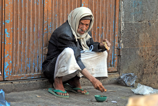 An elderly man eats bread in Sanaa, Yemen, on Friday (Anadolu Agency photo)