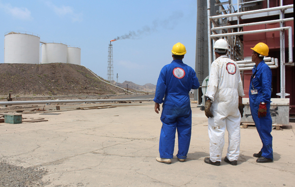 Yemeni oil workers look out at the Aden oil refinery after it was re-actived, on Monday, following a year of closure due to the on going conflict between pro-government forces and Shiite Houthi rebels near the southern embattled port city of Aden (AFP photo)