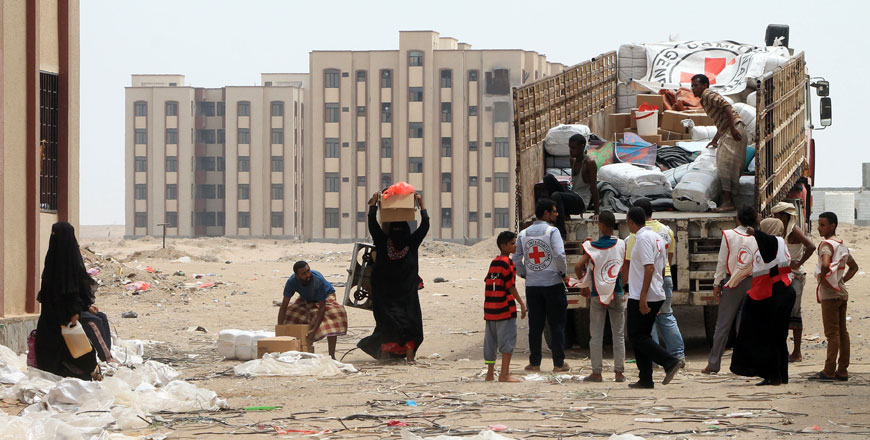 Members of the Yemeni Red Crescent distribute aid to displaced families in Al Saleh neighbourhood, north of the southern Yemeni city of Aden, on Monday as coalition air strikes continue to target rebel positions, and clashes between rebels and pro-government forces riddle the city (AFP photo)